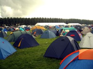 A camping field at a festival full of various tents