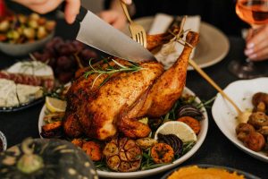 Festive meal with turkey being carved on a plate with trimmings.