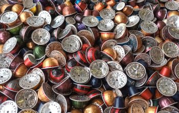 a large collection of spent coffee pods in a container ready for recycling