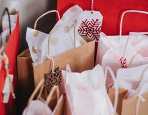 An image of a few brown paper gift bags with white tissue paper poking out the top.