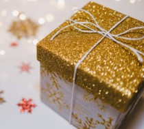 An image of a fancy gift box with a glittery gold top fixed with a string bow.