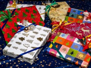 A selection of gifts wrapped in a variety of Christmas paper and ribbons.