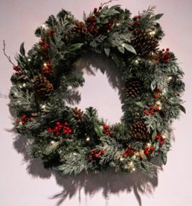 An image of a real foliage Christmas wreath with red berries.